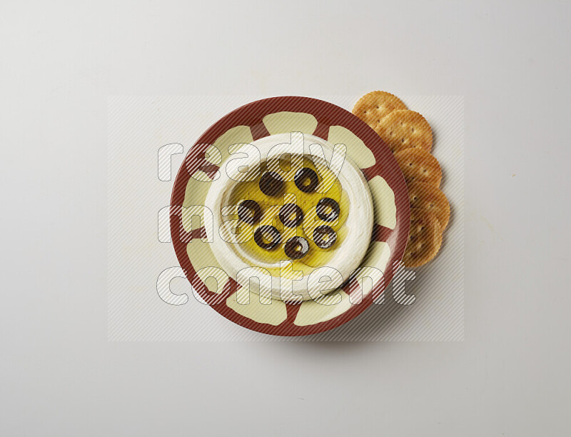 Lebnah garnished with sliced olives in a traditional plate on a white background