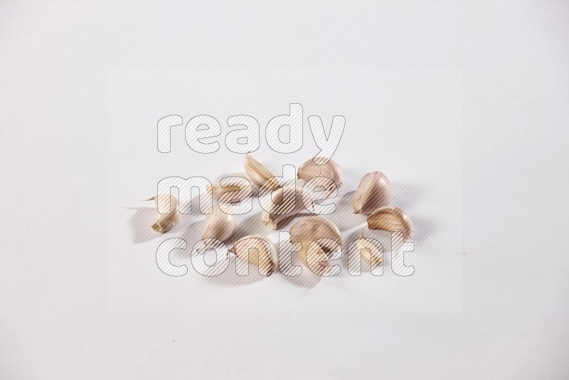 Garlic cloves on a white flooring in different angles