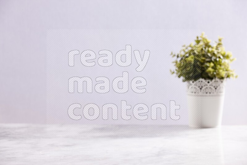 Artificial plant in white decorative pot on grey marble background
