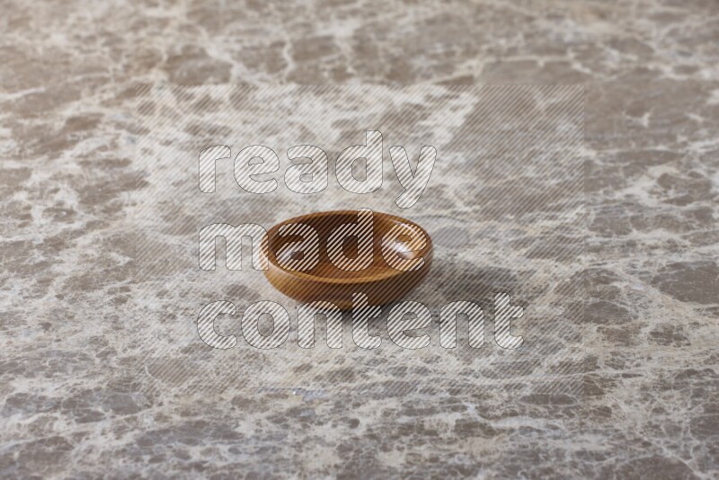 A wooden bowl on beige marble background