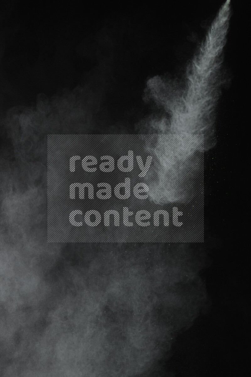 A side view of green powder explosion on black background