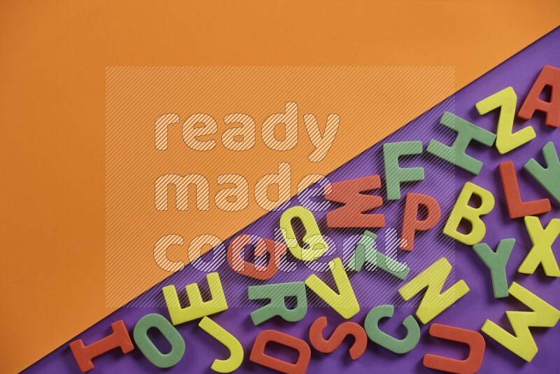 Colorful foam alphabets letters for kids on orange and purple background (kids toys)