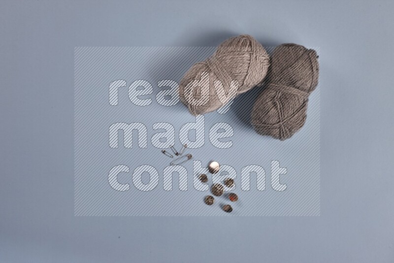 مجموعة من أدوات الخياطة والتفصيل رمادية اللون على خلفية زرقاء