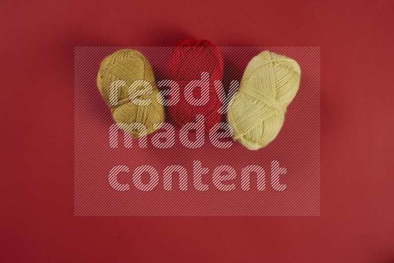 A yellow collection of sewing and tailoring tools arranged on a red background