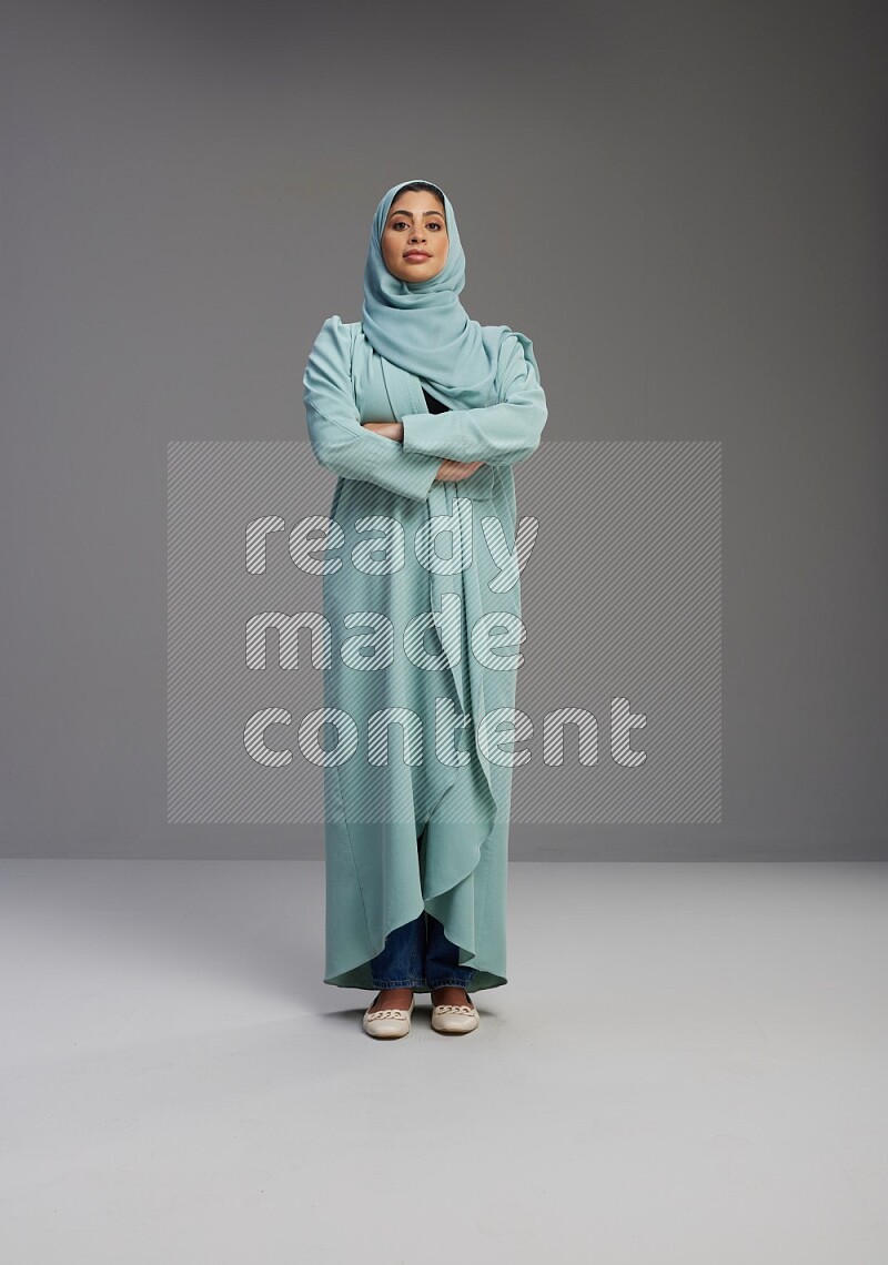Saudi Woman wearing Abaya standing with crossed arms on Gray background