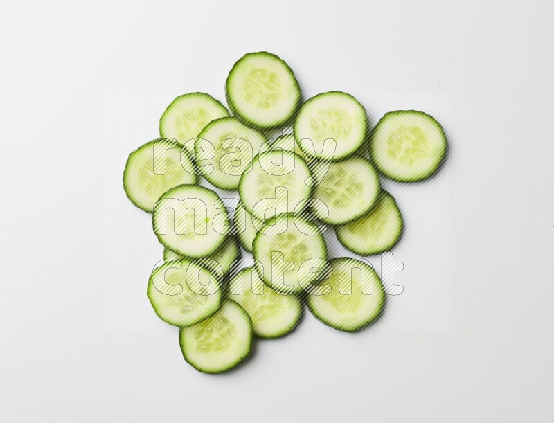 Multiple cucumber slices on white background