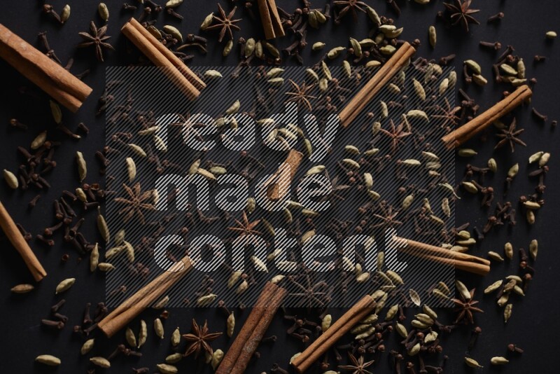 Cinnamon Sticks, Star anise, Cardamom and cloves on a black background