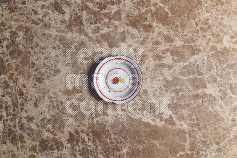 A vintage metal plate on beige marble background
