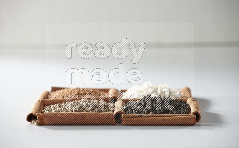 4 squares of cinnamon sticks full of mustard, salt, white pepper and black pepper on white flooring