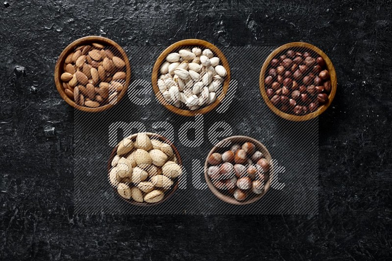 Nuts in wooden bowls in a dark setup