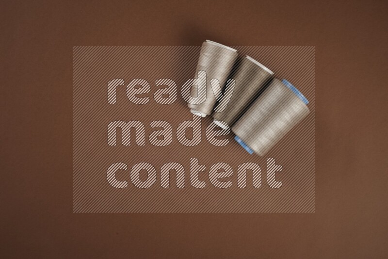 مجموعة من أدوات الخياطة والتفصيل بنية اللون على خلفية بنية