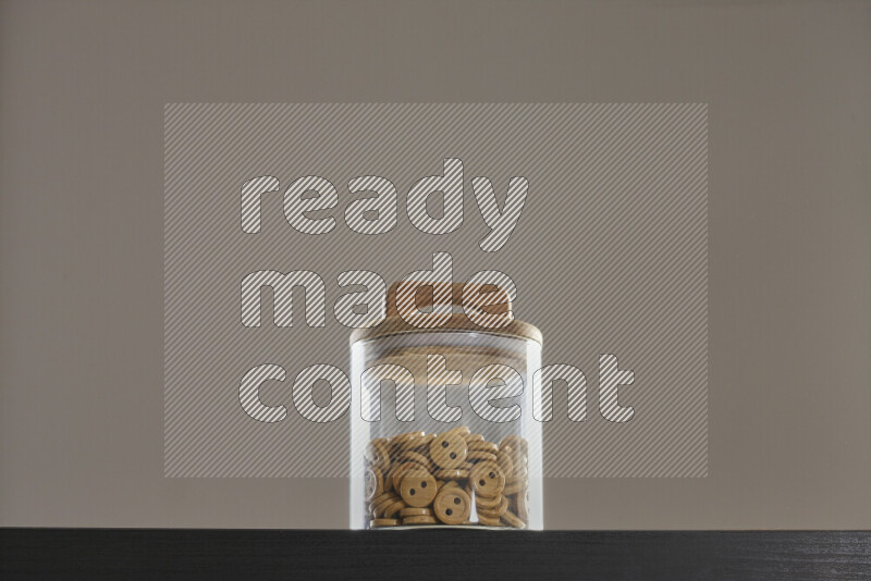 Buttons in a glass jar on black background
