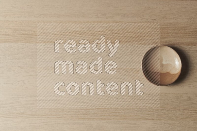 طبق من الفخار باللون البيج على خلفية خشبية فاتحة