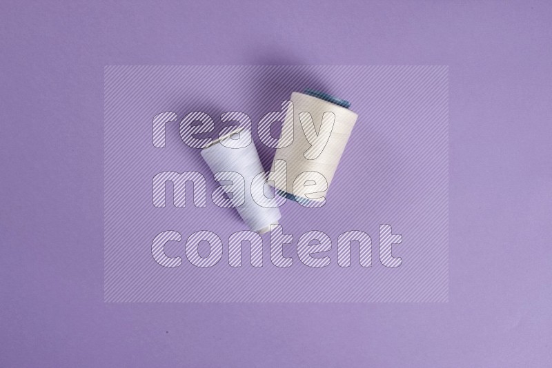 White sewing supplies on purple background