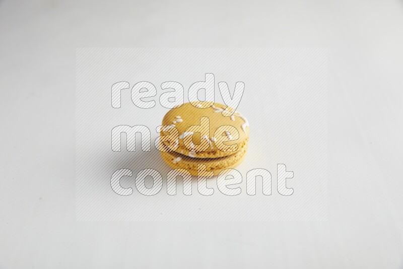 45º Shot of Yellow Piña Colada macaron on white background