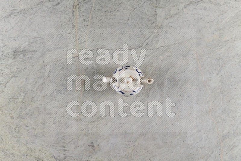 Top View Shot Of A Pottery Teapot On Grey Marble Flooring