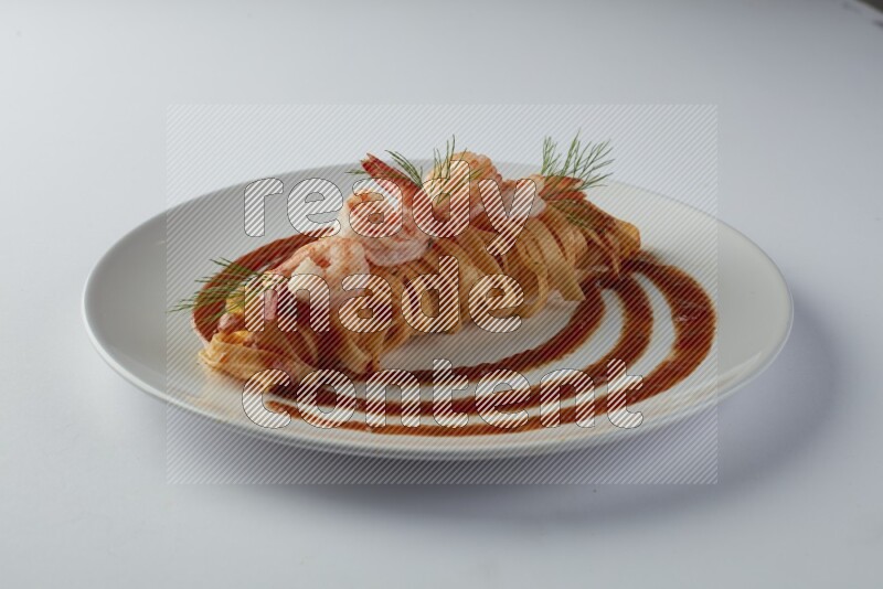 Fettuccini red sauce pasta with shrimp in a white plate on a white background
