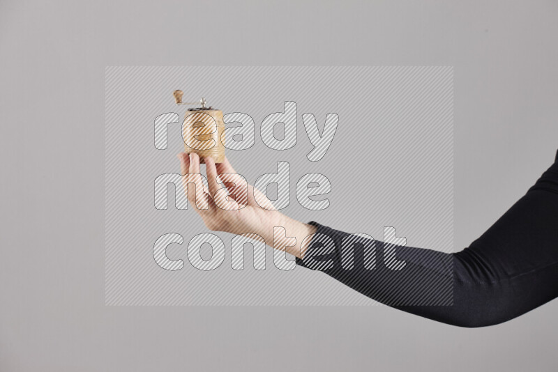 A woman in black abaya holding different wooden essentials in different positions
