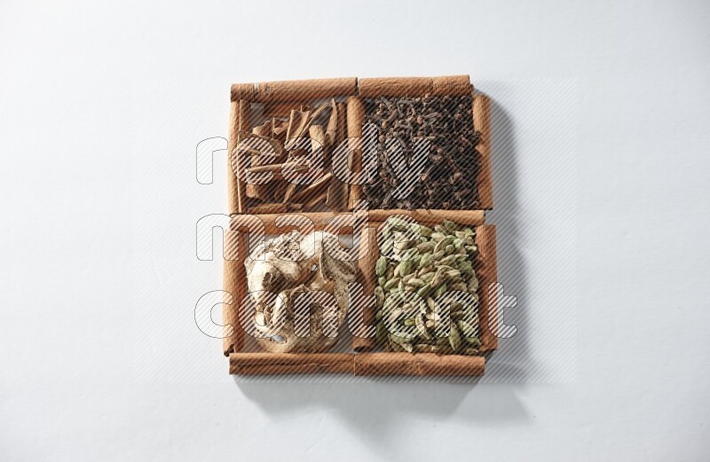 4 squares of cinnamon sticks full of cardamom, cinnamon, cloves and dried ginger on white flooring
