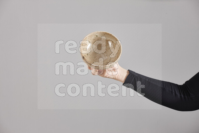 A woman in black abaya holding different pottery essentials in different positions