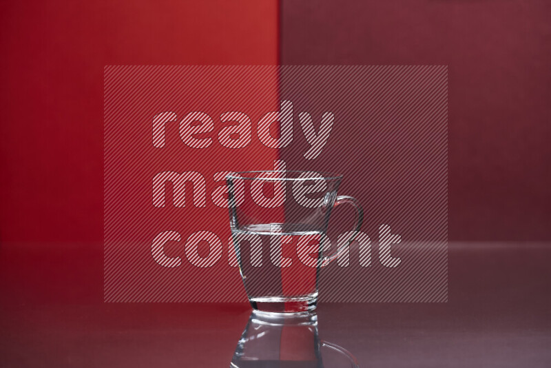 The image features a clear glassware filled with water, set against red and dark red background