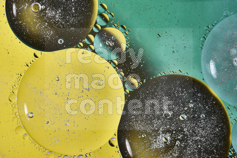 لقطات مقربة لفقاعات من الزيت على سطح الماء باللون الأخضر والأصفر
