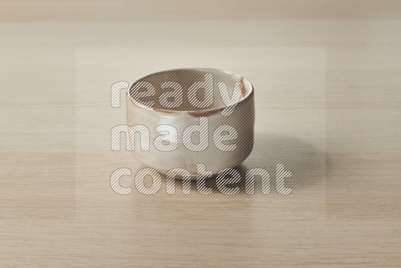 وعاء فخاري بيج على خلفية خشبية فاتحة