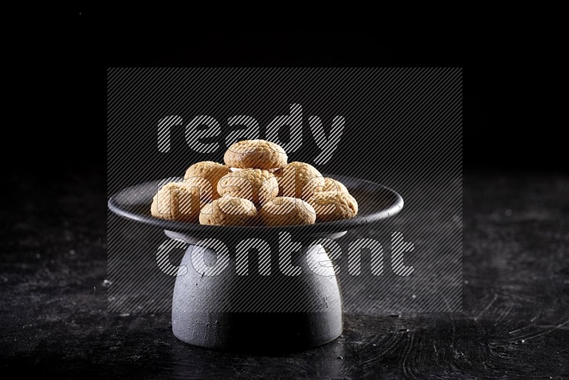 Kahk on a serving plate on a black background
