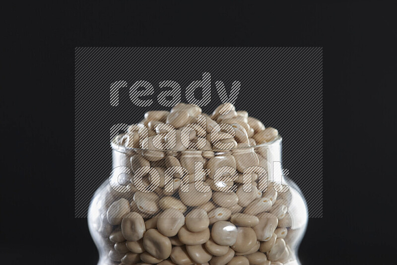 Lupin Beans in a glass jar on black background