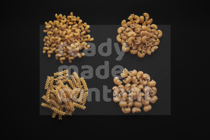 Different pasta types in bunches on black background