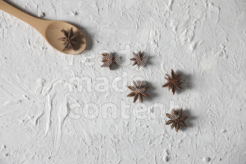 Star Anise in a wooden spoon on white flooring