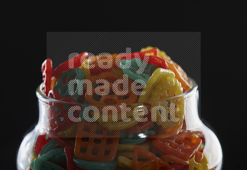 Snacks in a glass jar on black background