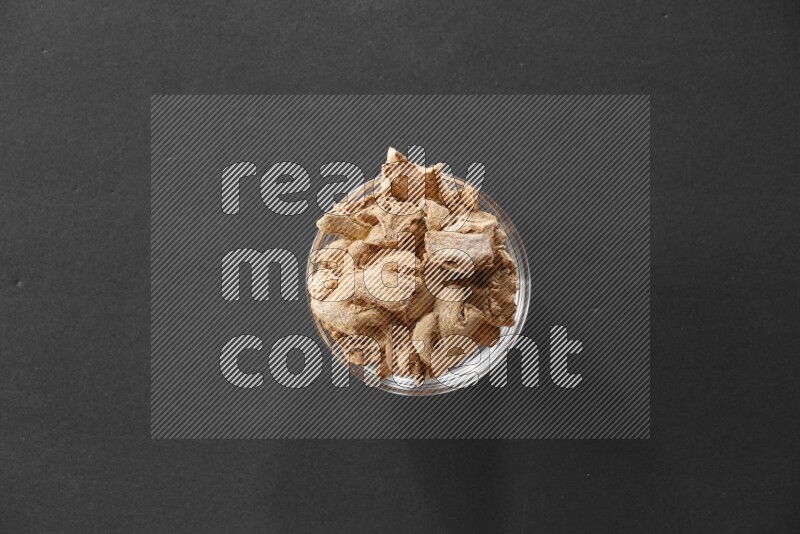 زنجبيل مجفف في وعاء زجاجي علي خلفية سوداء