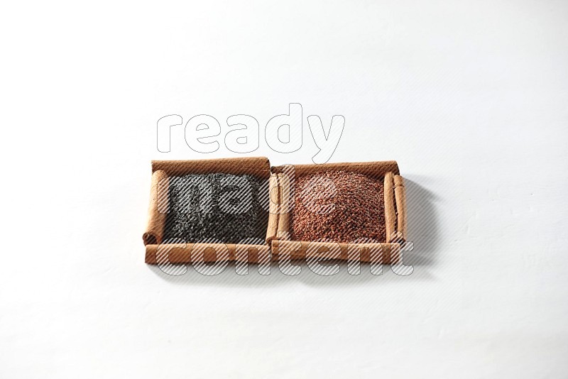 2 squares of cinnamon sticks full of black seeds and garden cress on white flooring