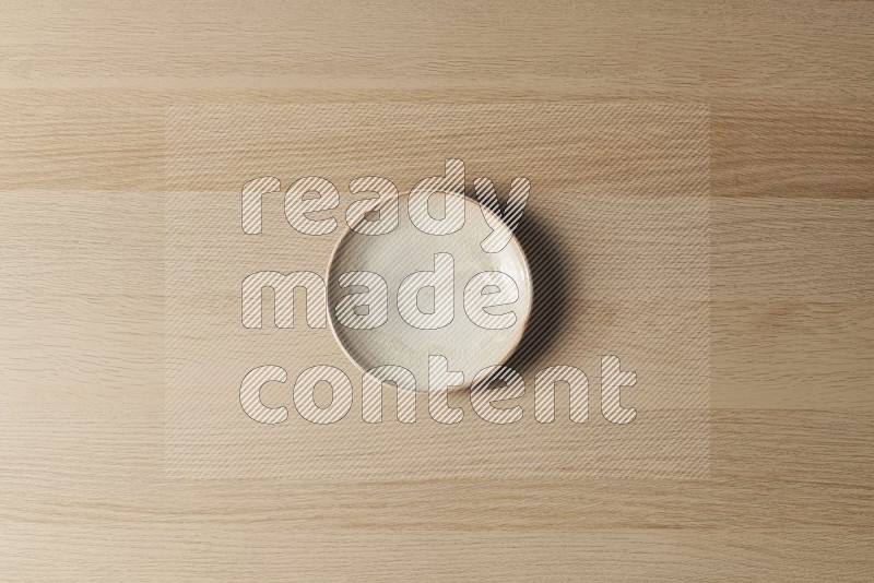 Top View Shot Of A Beige Pottery Plate on Oak Wooden Flooring