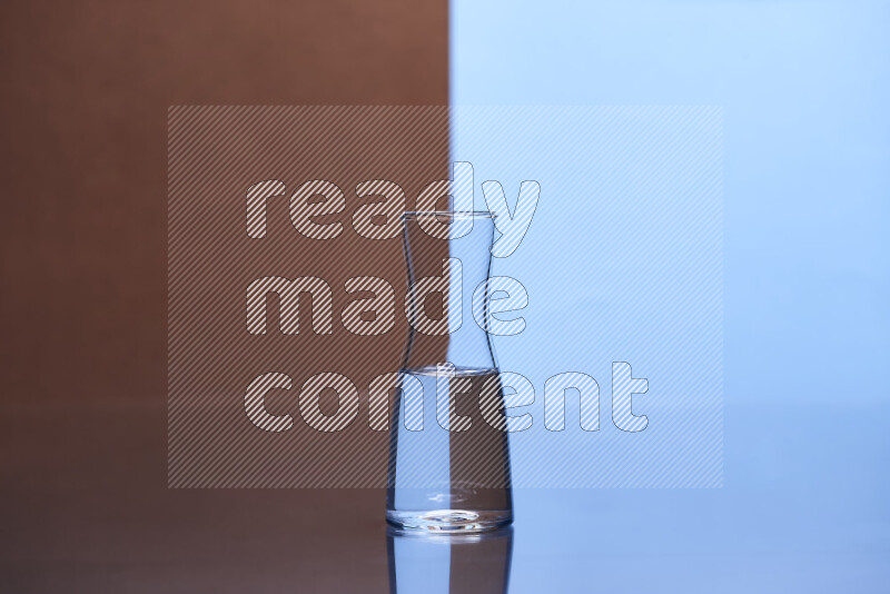تظهر الصورة أواني زجاجية ممتلئة بالماء موضوعة على خلفية من اللونين البني والأزرق الفاتح