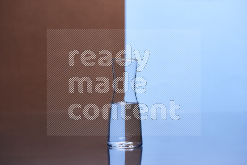 The image features a clear glassware filled with water, set against brown and light blue background