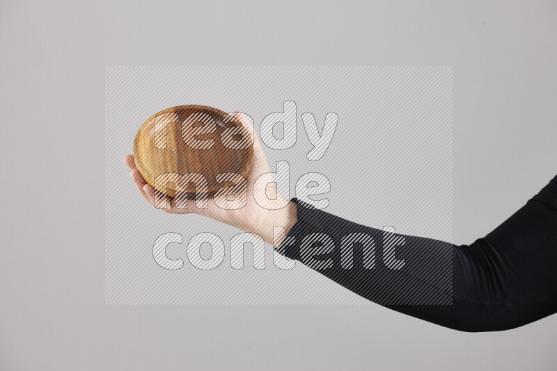 A woman in black abaya holding different wooden essentials in different positions