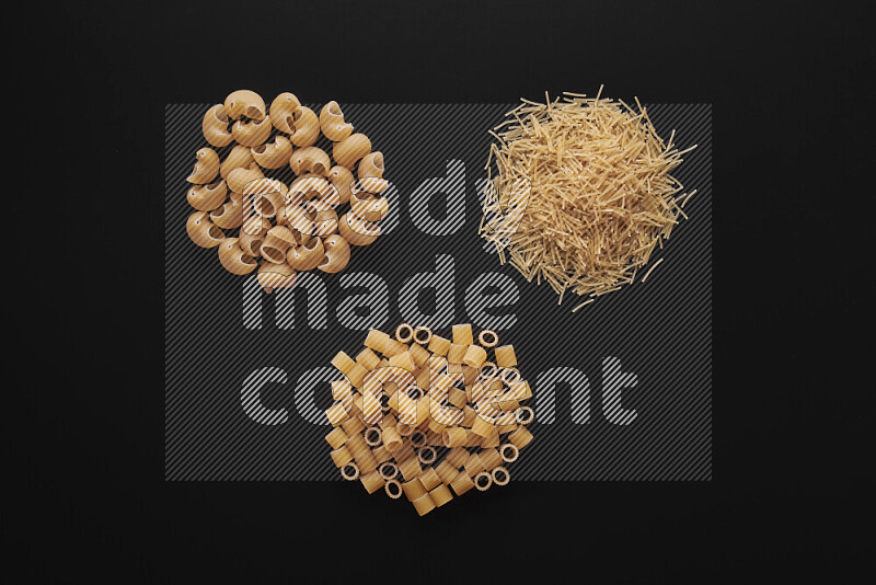 Different pasta types in bunches on black background