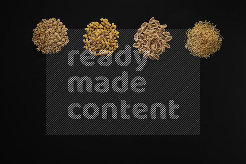 Different pasta types in 4 bunches on black background