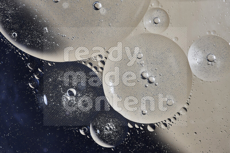 Close-ups of abstract oil bubbles on water surface in shades of black and beige