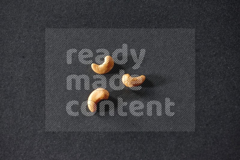 3 cashews on a black background in different angles