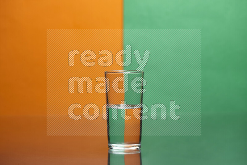 The image features a clear glassware filled with water, set against orange and green background
