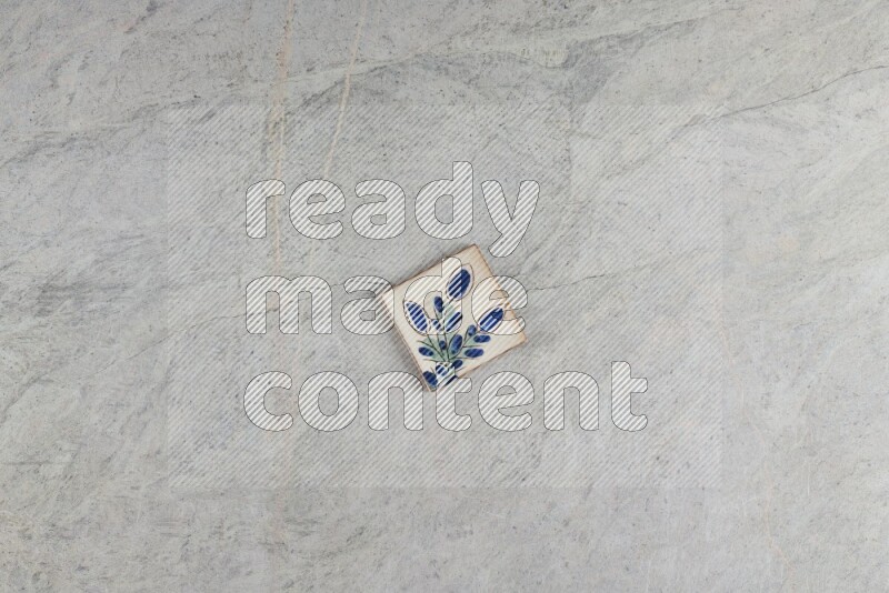 A decorative pottery coaster on grey marble background