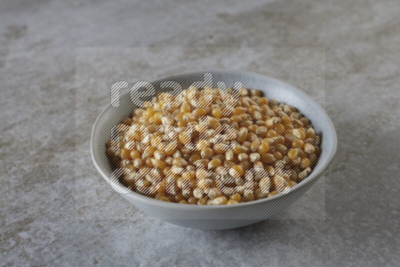 corn kernel in a gray ceramic bowl on a grey textured countertop