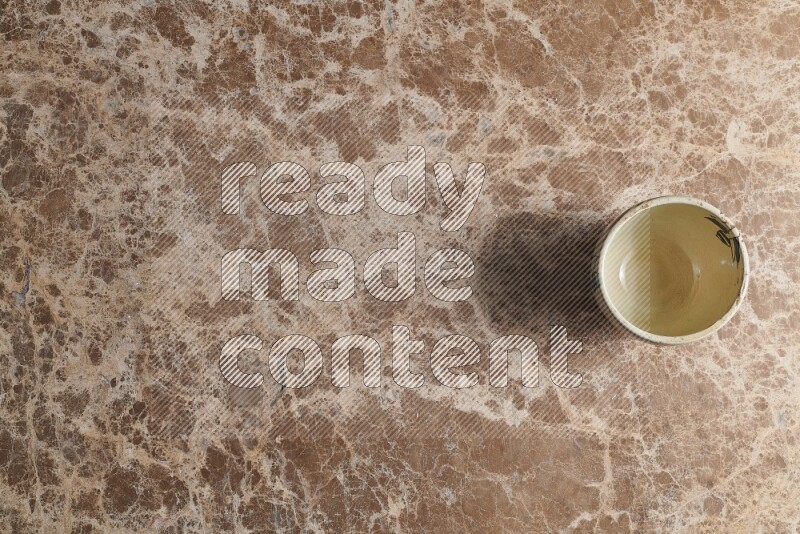 A white pottery bowl on beige marble background
