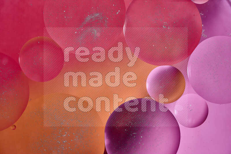 Close-ups of abstract oil bubbles on water surface in shades of red, orange and pink