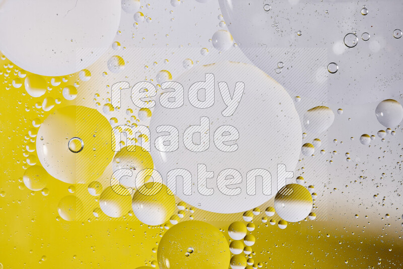 Close-ups of abstract oil bubbles on water surface in shades of white and yellow