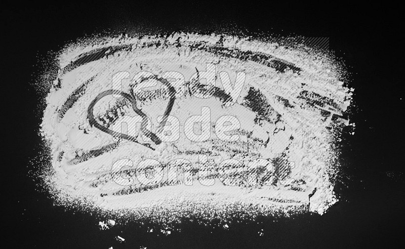 A heart drawn with powder on black background