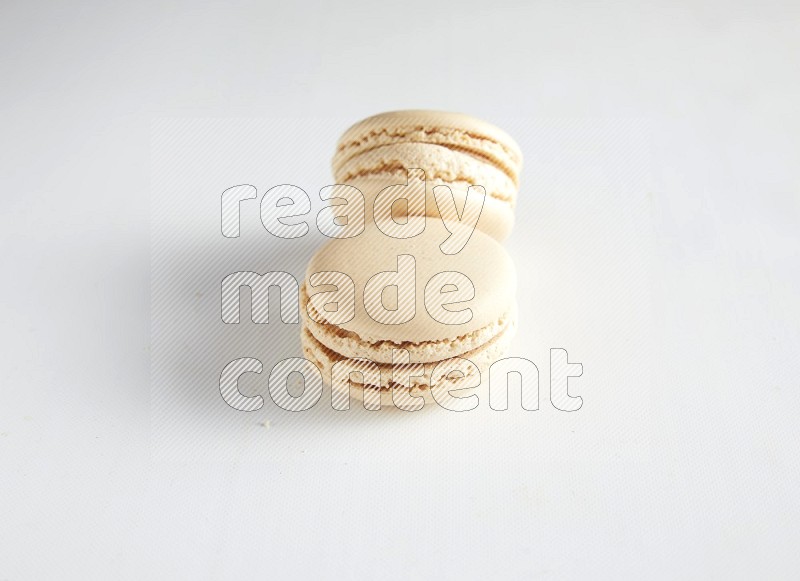 45º Shot of two White Caramel fleur de sel macarons on white background